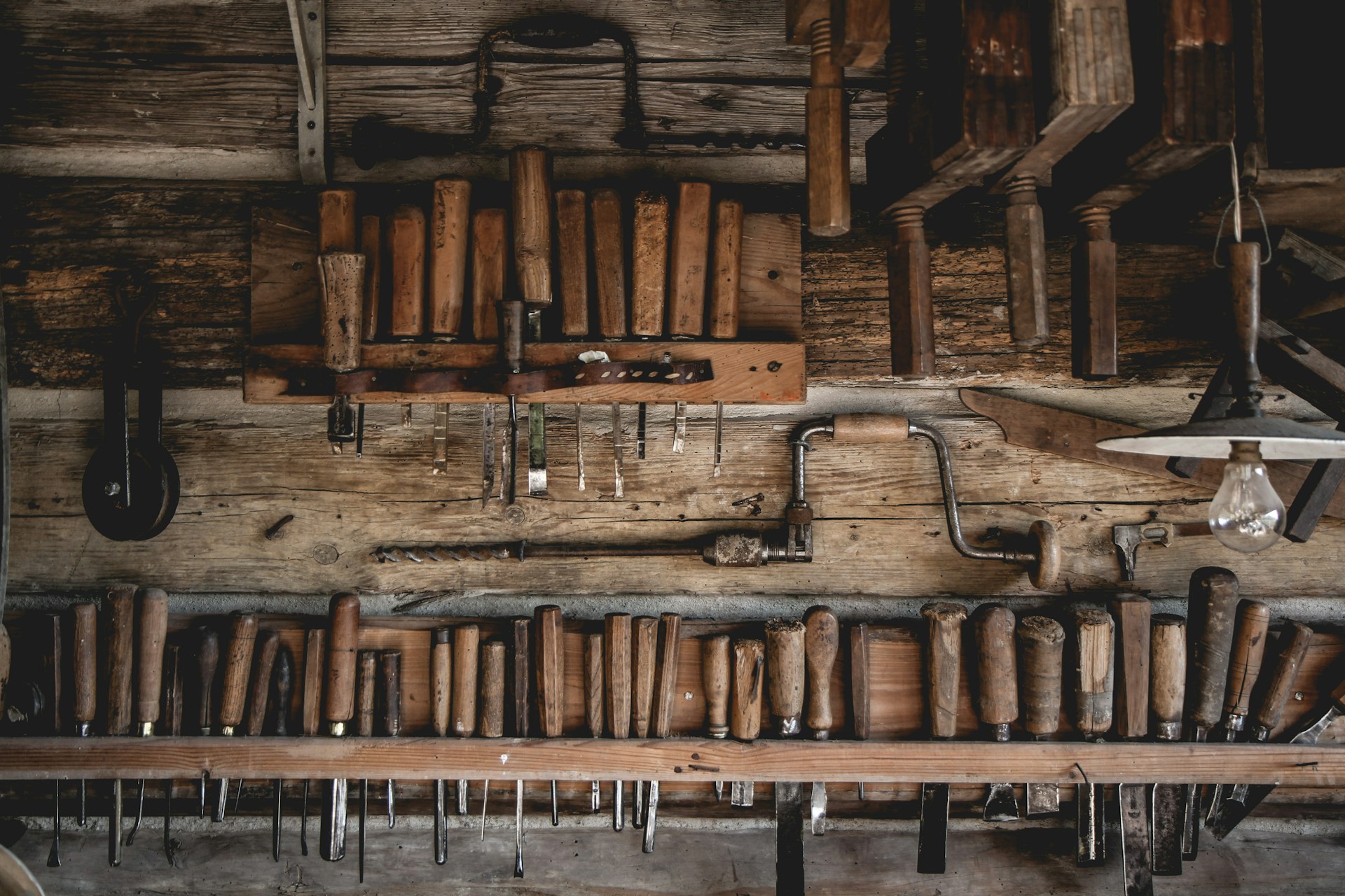 Oldschool hut and vintage tools on a wooden wall in a natural light